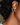 wide small gold hoop earrings shown on an ear. person wearing them has curly black hair. 